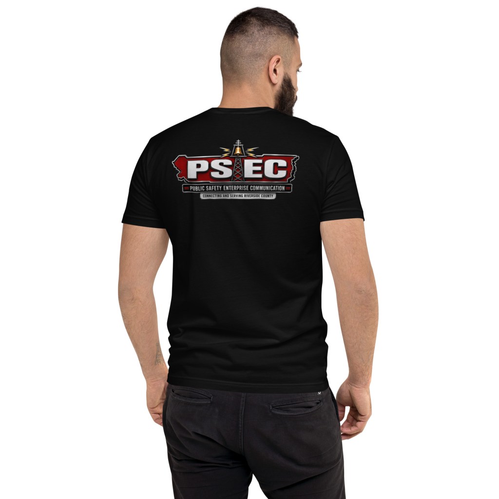 A man wearing a black t-shirt featuring the logo of Public Safety Enterprise Communication (PSEC) on the back, including the text 'Connecting and Serving Riverside County'.